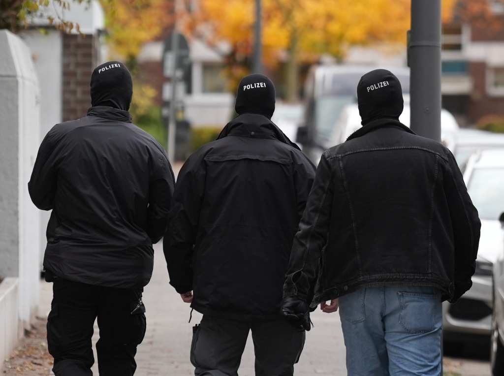 Police officers leave an apartment in the Mümmelmannsberg district after a raid, in Hamburg, Germany, Wednesday Nov. 5, 2025, as German Interior Minister Dobrindt has banned the Islamist association Muslim Interaktiv. (Marcus Brandt/dpa via AP)