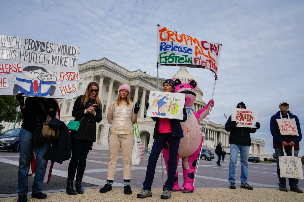 Protesters hold signs during a news conference on the Epstein Files Transparency Act, Tuesday, Nov. 18, 2025, outside the U.S. Capitol in Washington. (AP Photo/Julia Demaree Nikhinson)