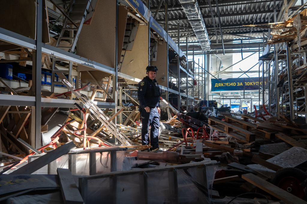 A police officer inspects a commercial facility damaged in a Russian drone attack in Kharkiv, Ukraine, Thursday, Sept. 17, 2026. (AP Photo/Andrii Marienko)