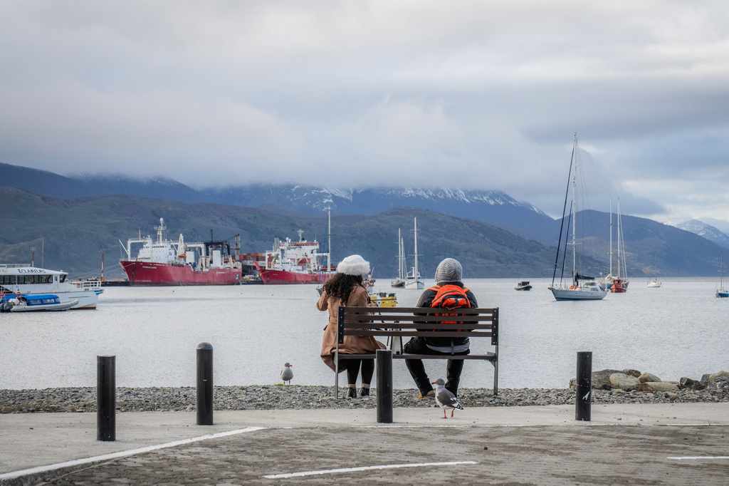 People sit on a bench in Ushuaia, Argentina, Thursday, May 14, 2026. (AP Photo/Joel Reyero)