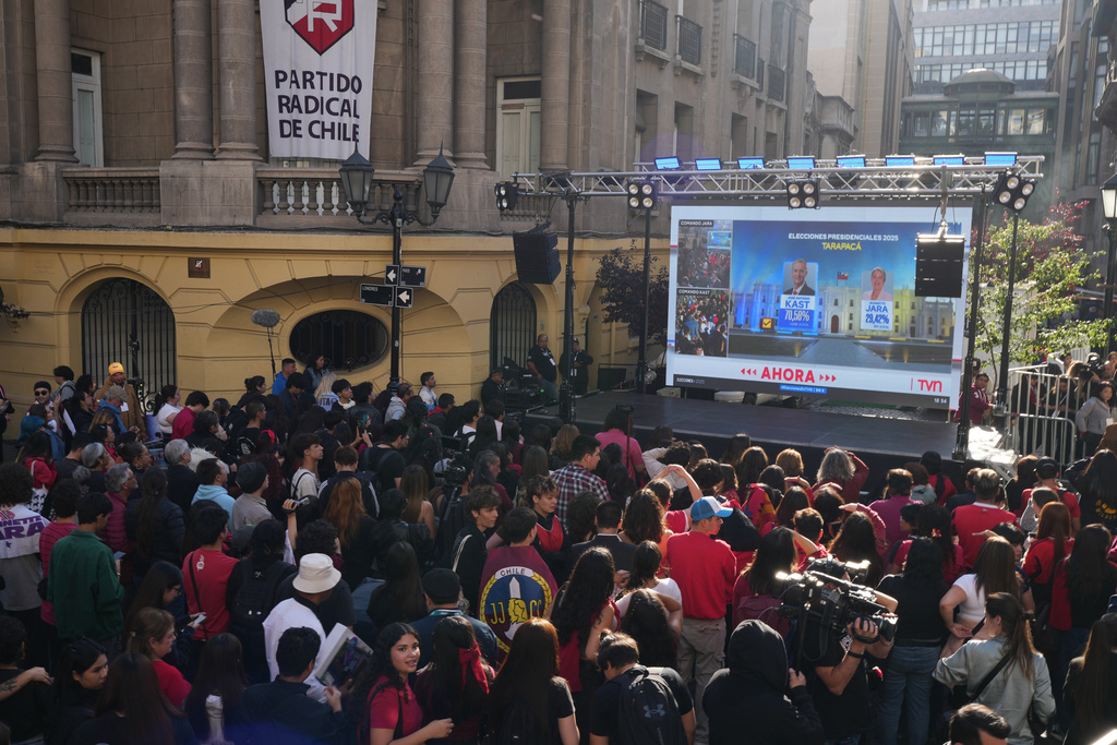 A screen displays preliminary results at the campaign headquarters of Jeannette Jara, presidential candidate of the ruling Unity for Chile coalition, after polls closed for the presidential runoff in Santiago, Chile, Sunday, Dec. 14, 2025.(AP Photo/Natacha Pisarenko)
