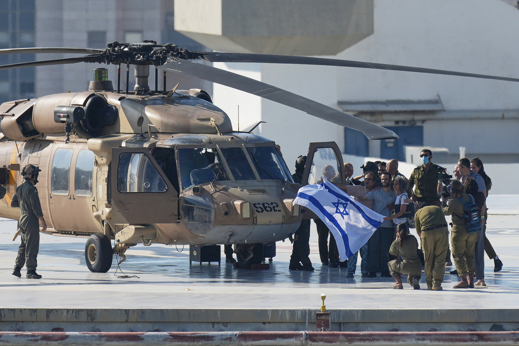 Nimrod Cohen, an Israeli hostage released from the Gaza Strip holds an Israeli flag after coming off a helicopter at the Ichilov Hospital, in Tel Aviv, Israel, Monday, Oct. 13, 2025. (AP Photo/Ohad Zwigenberg)