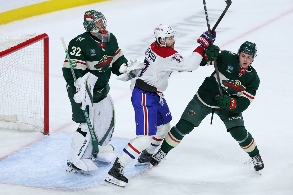 Minnesota Wild defenseman Brock Faber, right, and Montréal Canadiens right wing Josh Anderson, center, compete for position as Wild goaltender Filip Gustavsson defends his net during the second period of an NHL hockey game Monday, Feb. 2, 2026, in St. Paul, Minn. (AP Photo/Matt Krohn)