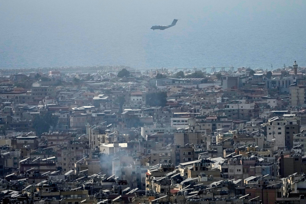 A French plane carrying humanitarian aid to Lebanon is seen through buildings in Dahiyeh, Beirut's southern suburbs, landing at Rafik Hariri International Airport, Thursday, March 12, 2026. (AP Photo/Hussein Malla)