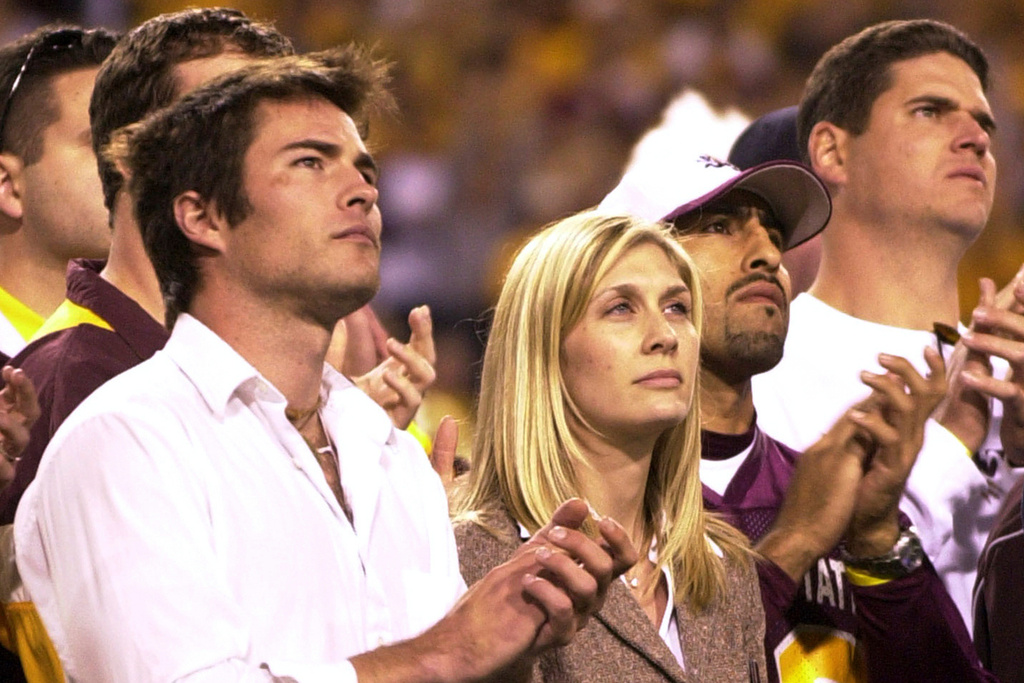 FILE - Former Arizona State player Pat Tillman's wife Marie Tillman, center, and his brother Richard Tillman, left, applaud as they watch Pat's name and jersey number enshrined in the university's ring of honor during halftime ceremonies between Washington State and Arizona State, Nov. 13, 2004, in Tempe, Ariz. (AP Photo/Paul Connors, File)