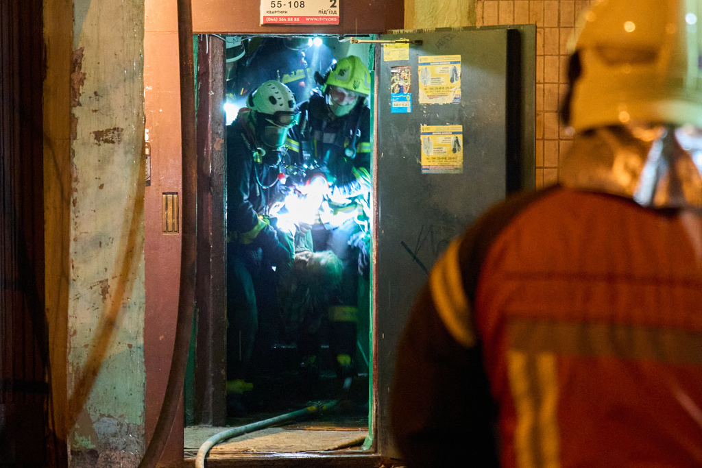 Rescuers carry the body of a civilian who was killed as a drone hit a multi-storey residential building during Russia's night drone attack in Kyiv, Ukraine, Tuesday, Nov. 25, 2025. (AP Photo/Efrem Lukatsky)