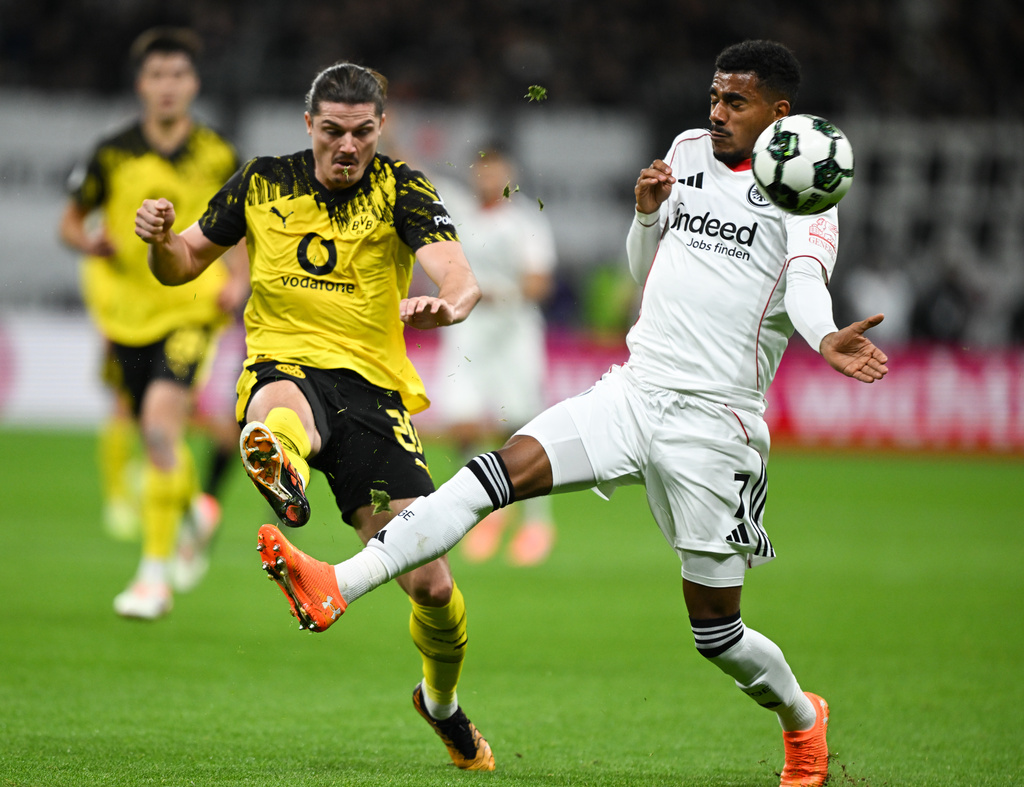 Frankfurt's Ansgar Knauff, right, and Dortmund's Marcel Sabitzer, left, challenge for the ballduring a German soccer cup second round match between Eintracht Frankfurt and Borussia Dortmund in Frankfurt, Germany, Tuesday, Oct. 28, 2025. (Arne Dedert/dpa via AP)