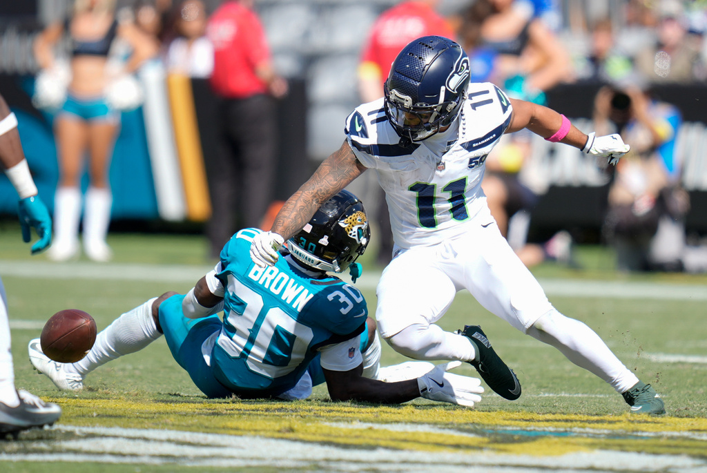 Jacksonville Jaguars cornerback Montaric Brown (30) breaks up a pass intended for Seattle Seahawks wide receiver Jaxon Smith-Njigba (11) during the second half of an NFL football game Sunday, Oct. 12 2025, in Jacksonville, Fla. (AP Photo/John Raoux)