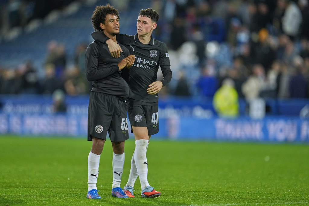 Manchester City's Phil Foden, right, celebrates with teammate Oscar Bobb at the end of the English League Cup third round soccer match between Huddersfield and Manchester City at the John Smith's stadium, in Huddersfield, England, Wednesday, Sept. 24, 2025. (AP Photo/Jon Super),