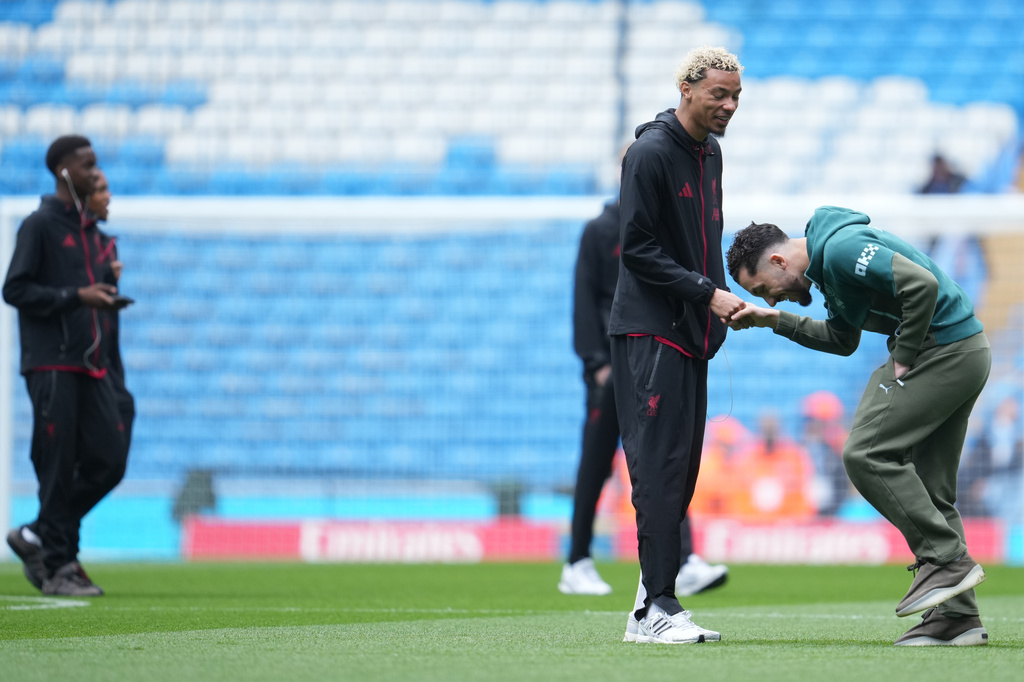 Liverpool's Hugo Ekitike, left, talks to Manchester City's Rayan Cherki before the FA Cup quarter-final soccer match between Manchester City and Liverpool in Manchester, England, Saturday, April 4, 2026. (AP Photo/Jon Super)