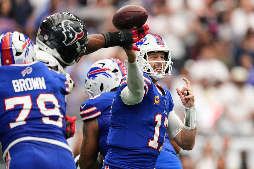 Buffalo Bills quarterback Josh Allen (17) throws an incomplete pass forced by Houston Texans defensive end Danielle Hunter, second from left, during the second half of an NFL football game, Sunday, Sept. 13, 2026, in Houston. (AP Photo/Ashley Landis)
