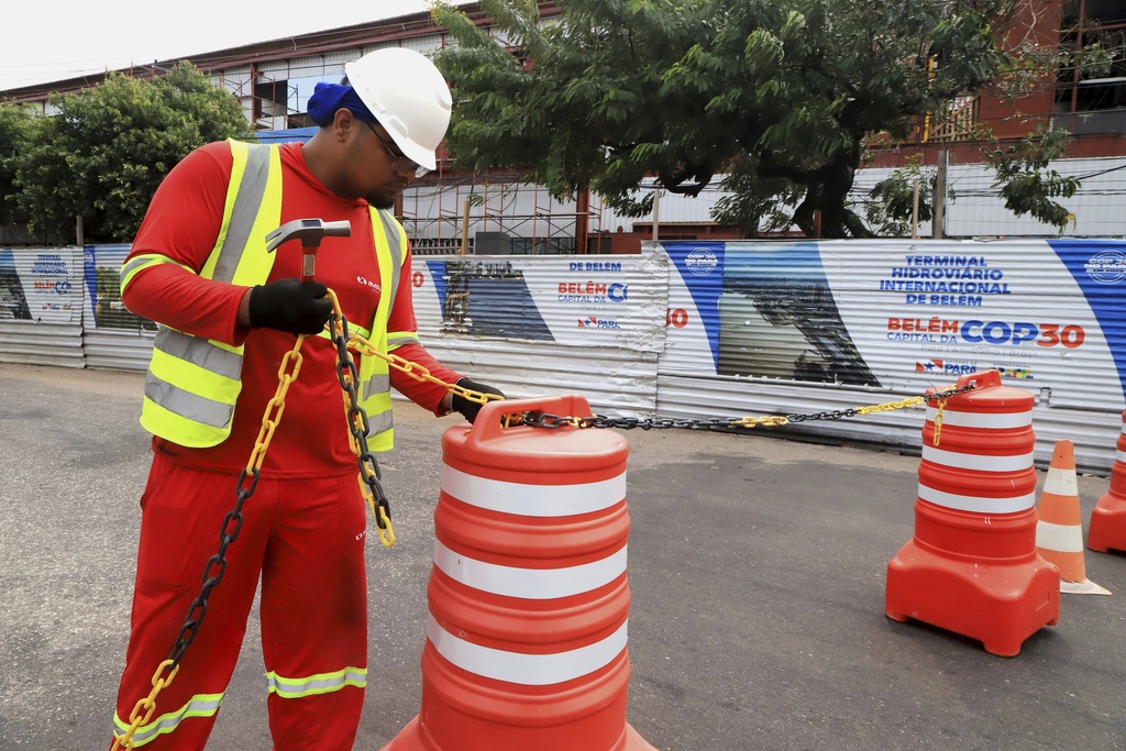 A worker blocks the street to car traffic during construction for the upcoming COP30 U.N. Climate Summit in Belem, Brazil, Sept.18, 2025. (AP Photo/Paulo Santos)