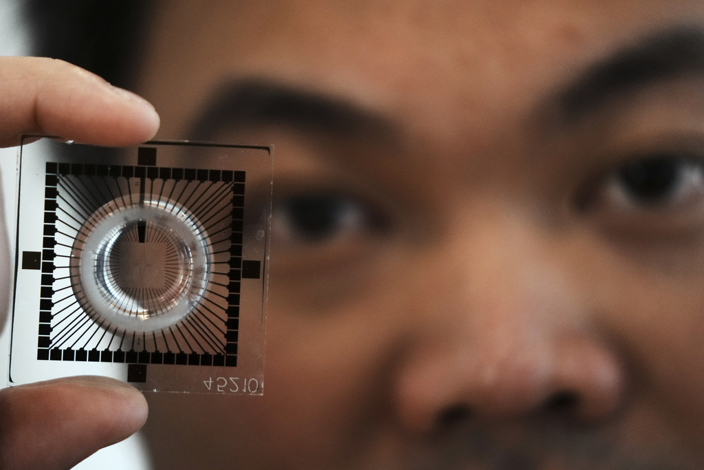 Dr Hon Weng Chong CEO of Cortical Labs showing a chip used to grow neurons into for computation and AI processing at the first International Humanoid Olympiad at the Olympic Academy, in ancient Olympia, Greece, Monday, Sept. 1, 2025. (AP Photo/Thanassis Stavrakis)