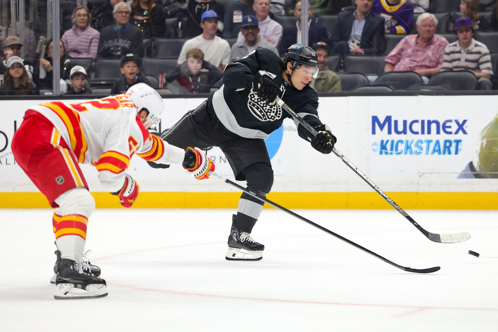 Los Angeles Kings left wing Trevor Moore, right, shoots against Calgary Flames defenseman MacKenzie Weegar during the second period of an NHL hockey game Saturday, Feb. 28, 2026 in Los Angeles. (AP Photo/Ryan Sun)