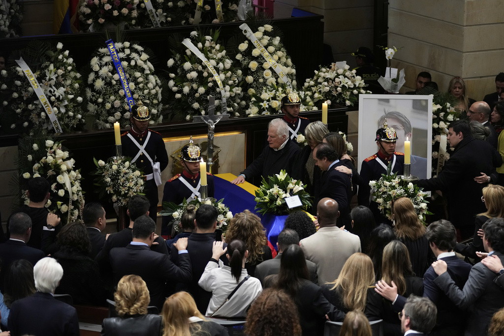 Miguel Uribe, the father of presidential hopeful and opposition Sen. Miguel Uribe, touches his son's coffin, at Congress in Bogota, Colombia, Monday, Aug. 11, 2025, after the senator died from wounds suffered when he was shot at a political rally. (AP Photo/Fernando Vergara)