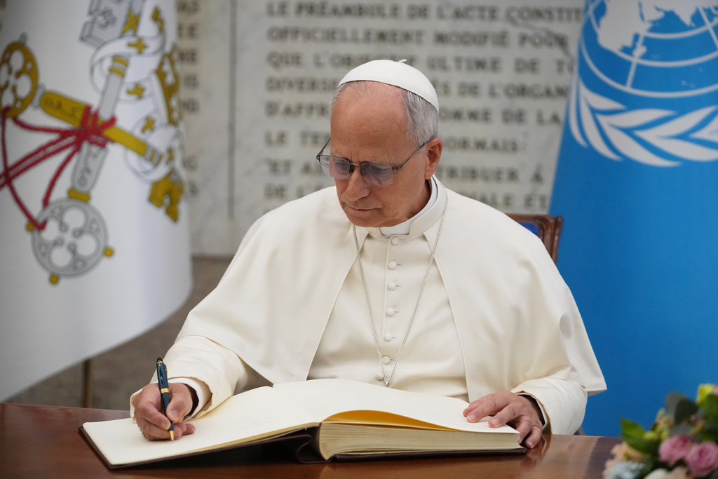 Pope Leo XIV signs the FAO Golden Book register of honor as he attends a ceremony marking the 80th anniversary of World Food Day at the FAO headquarters in Rome, Thursday, Oct. 16, 2025. (AP Photo/Alessandra Tarantino)