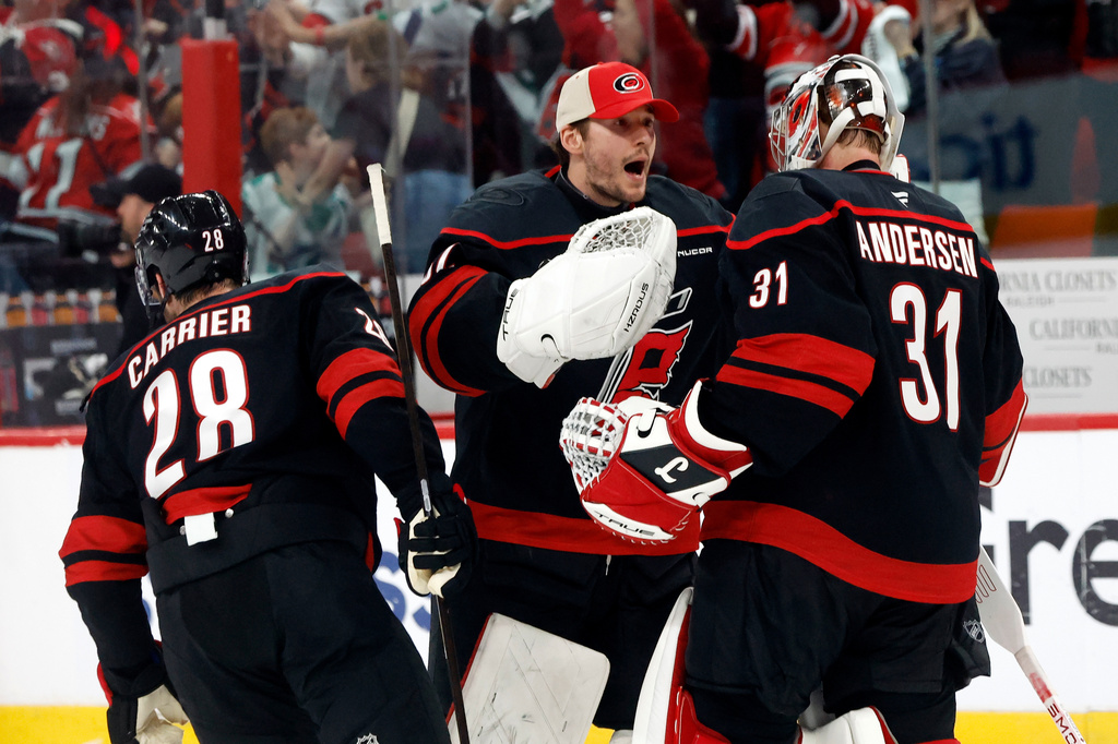 Carolina Hurricanes goaltender Brandon Bussi (32) congratulates goaltender Frederik Andersen (31) with William Carrier (28), following the second overtime of Game 2 of an NHL hockey Stanley Cup first-round playoff series against the Ottawa Senators in Raleigh, N.C., Monday, April 20, 2026. (AP Photo/Karl DeBlaker)