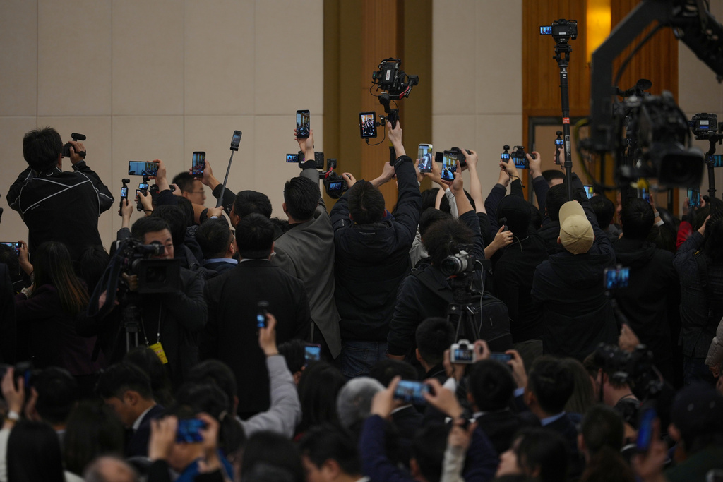 Journalists film as Chinese Foreign Minister Wang Yi arrives for a press conference on the sideline of the National People's Congress (NPC) at the media center, in Beijing, Sunday, March 8, 2026. (AP Photo/Andy Wong)