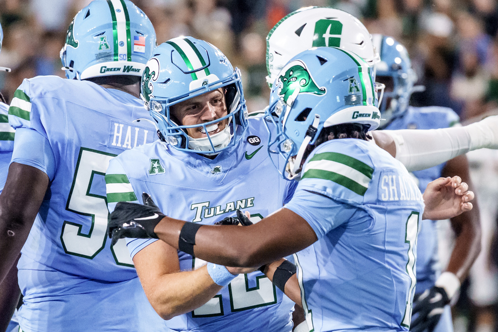 Tulane quarterback Jake Retzlaff (12) and Tulane wide receiver Tre Shackelford (11) react after a touchdown during the first half of an NCAA college football game against Charlotte in New Orleans, Saturday, Nov. 29, 2025. (AP Photo/Matthew Hinton)