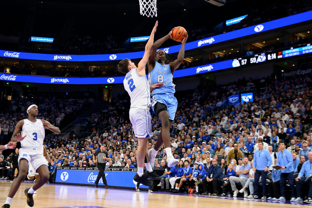 North Carolina forward Caleb Wilson (8) goes to the basket defended by BYU forward Tyler Mrus (2) during the second half of an NCAA college basketball exhibition game, Friday, Oct. 24, 2025, in Salt Lake City, Utah. (AP Photo/Tyler Tate)
