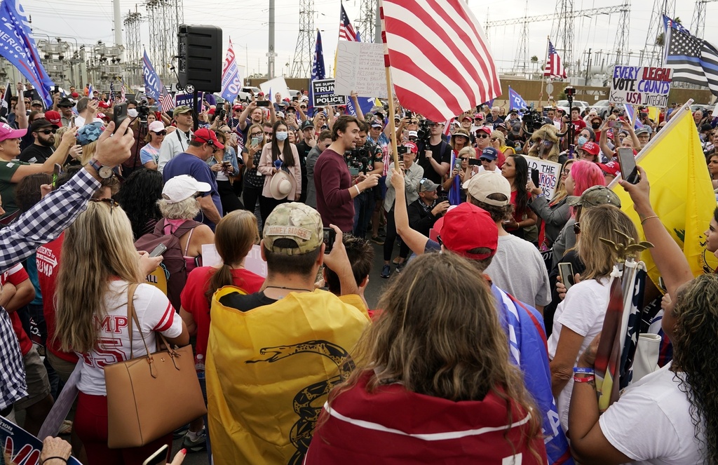 FILE - Charlie Kirk, center, conservative activist and founder of Turning Point USA, speaks to supporters of President Donald Trump at a rally, Nov. 6, 2020, in Phoenix. (AP Photo/Ross D. Franklin, File)