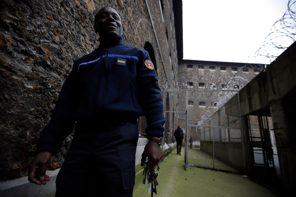 FILE - A security guard walks in the courtyard of La Sante prison, in Paris, Friday, Nov. 21, 2014, during a press visit as it begins a four-year renovation project. (AP Photo/Francois Mori, File)
