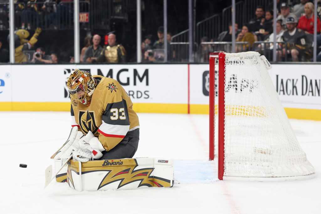 Vegas Golden Knights goaltender Adin Hill makes a save against the Calgary Flames during the first period of an NHL hockey game Saturday, Oct. 18, 2025, in Las Vegas. (AP Photo/Ian Maule)
