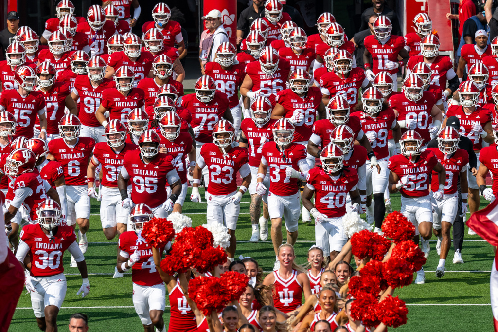 Indiana players and coaches run onto the field before an NCAA college football game against Western Kentucky, Saturday, Sept. 19, 2026, in Bloomington, Ind. (AP Photo/Doug McSchooler)