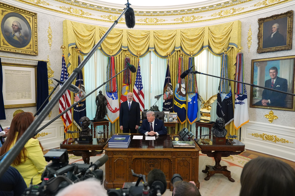 President Donald Trump answers questions from reporters after signing an executive order in the Oval Office of the White House Tuesday, March 31, 2026, in Washington, as Commerce Secretary Howard Lutnick listens. (AP Photo/Alex Brandon)