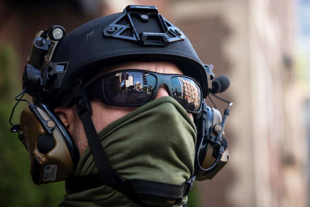 FILE - Federal immigration enforcement agents keep watch as they detain a man who took off running as they were walking on North Clark Street near West Superior Street in the River North neighborhood, Sept. 28, 2025, in Chicago. (Ashlee Rezin/Chicago Sun-Times via AP, File)