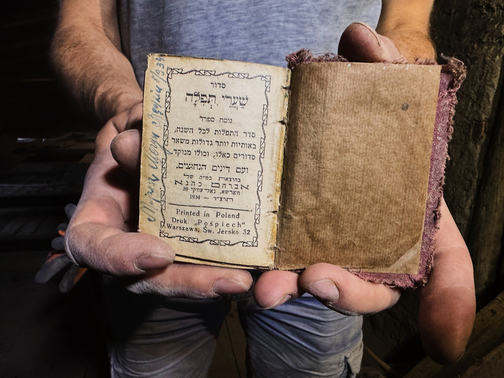 Wojciech Mazan, museologist and art historian shows a Hebrew prayer book from 1934, found in the attic of the "Bedzin Ghetto Fighters Memorial" house in Bedzin, Poland, on May 29, 2026. (AP Photo/Rafal Niedzielski)
