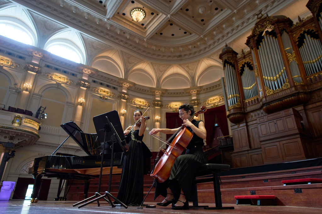 Violinist Hyunjin Cho, left, and cellist Efstratia Chaloulakou perform for students studying with music at Concertgebouw in Amsterdam, Netherlands, on March 5, 2026. (AP Photo/Peter Dejong)