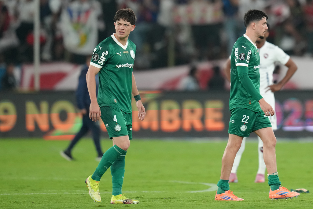 Agustin Giay, left, and Piquerez of Brazil's Palmeiras leave the pitch after losing to Ecuador's Liga Deportiva Universitaria during a Copa Libertadores semifinal first leg soccer match in Quito, Ecuador, Thursday, Oct. 23, 2025. (AP Photo/Dolores Ochoa)