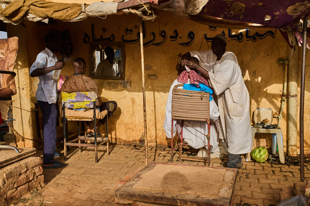 Street barbers work at a market in Omdurman, on the outskirts of Khartoum, Sudan, Sunday, April 26, 2026. (AP Photo/Bernat Armangue)