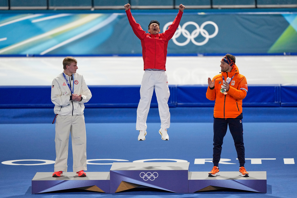 Ning Zhongyan of China, center and gold medal, Jordan Stolz of the U.S., left and silver medal, and Kjeld Nuis of the Netherlands, right and bronze medal, celebrate on the podium of the men's 1500 meters speedskating race at the 2026 Winter Olympics, in Milan, Italy, Thursday, Feb. 19, 2026. (AP Photo/Ben Curtis)