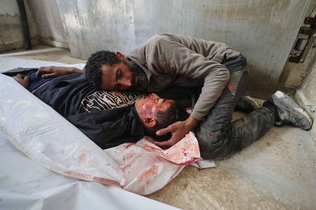 EDS NOTE: GRAPHIC CONTENT - Yusuf Zawara mourns over the body of his son, Mohammad Zawara, 15, who was killed in an Israeli strike, according to health officials, at Shifa Hospital, Gaza City, Saturday, Jan. 24, 2026. (AP Photo/Yousef Al Zanoun)