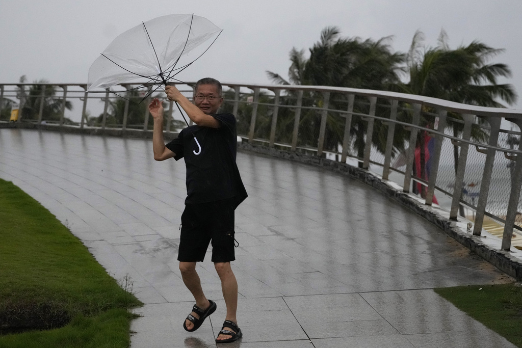 A man holds on to his umbrella against strong winds ahead of Super Typhoon Ragasa in Shenzhen in southern China's Guangdong province on Tuesday, Sept. 23, 2025. (AP Photo/Ng Han Guan)