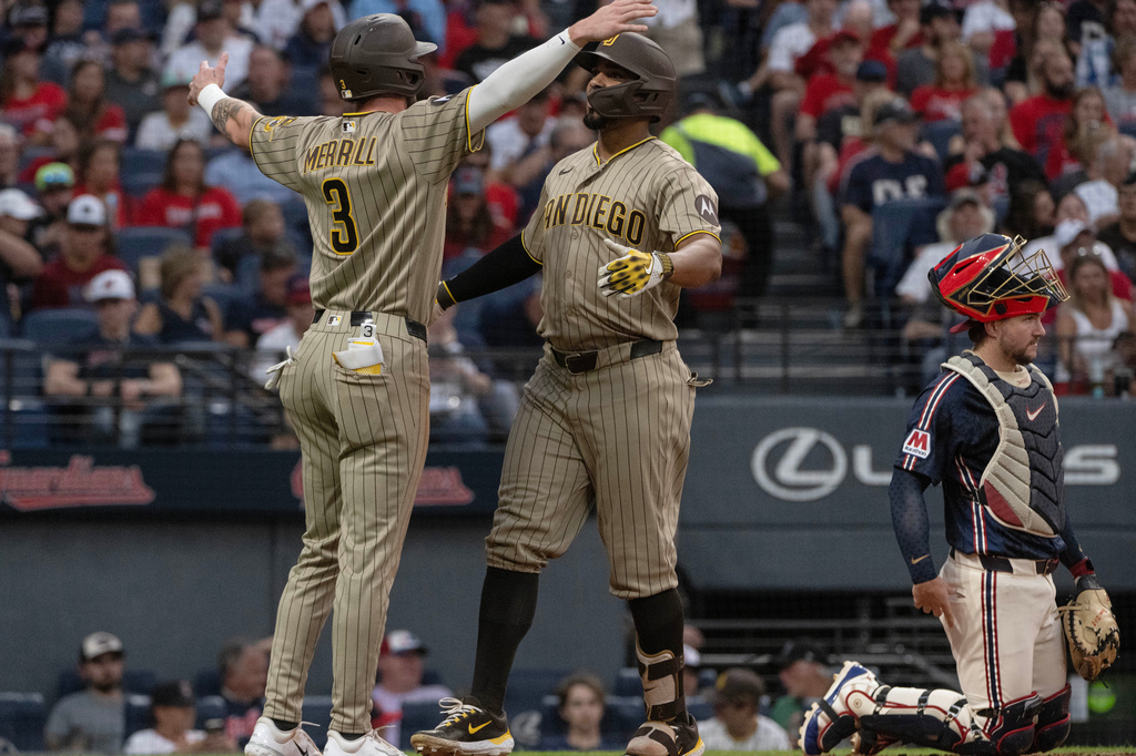 San Diego Padres' Jackson Merrill (3) congratulates Xander Bogaerts, center, after Bogaerts hit a two-run home run off Cleveland Guardians starting pitcher Gavin Williams during the fourth inning of a baseball game, Friday, Aug. 14, 2026, in Cleveland. (AP Photo/Phil Long)