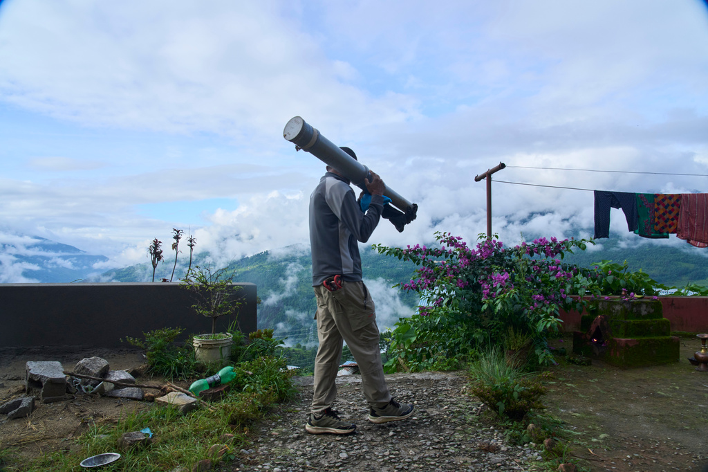 Ganesh Karki, 44, carries a homemade cannon that creates noise used to chase monkeys away from nearby farmlands in Dharamghar, Dolakha district, about 86 kilometers (53 miles) east of Kathmandu, Nepal, Saturday, July 25, 2026. (AP Photo/Niranjan Shrestha) CORRECTION: Corrects date to July 25 instead of July 27.