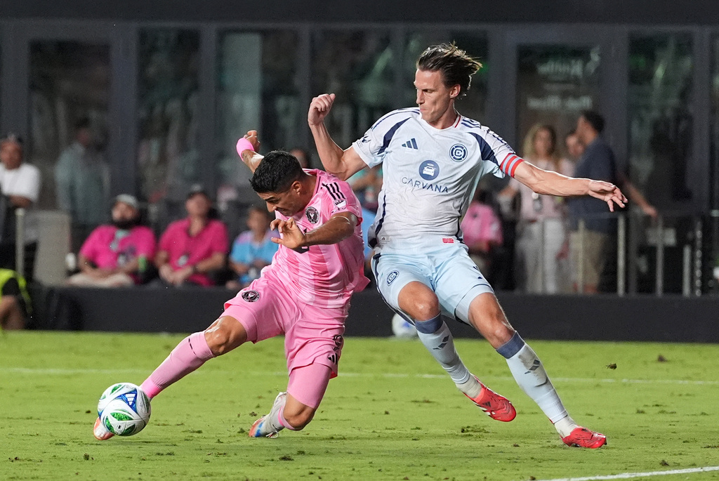 Inter Miami forward Luis Suarez, left, scores his side's second goal past Chicago Fire defender Jack Elliott during the second half of an MLS soccer match, Tuesday, Sept. 30, 2025, in Fort Lauderdale, Fla. (AP Photo/Rebecca Blackwell)