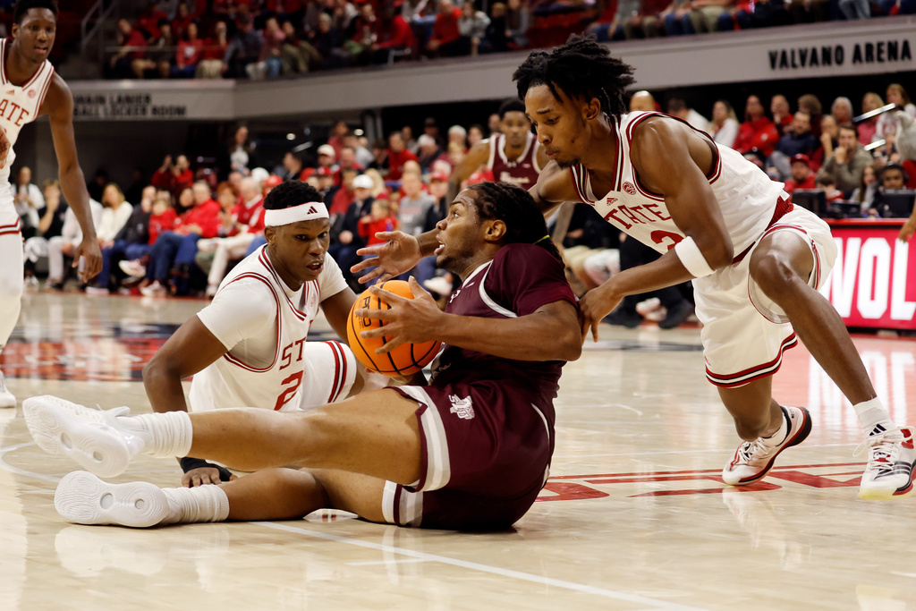 Texas Southern's Troy Hupstead, center, tries to pass the ball with North Carolina State's Jr. Paul McNeil (2) and Ven-Allen Lubin, closing in during the first half of an NCAA college basketball game in Raleigh, N.C., Wednesday, Dec. 17, 2025. (AP Photo/Karl DeBlaker)