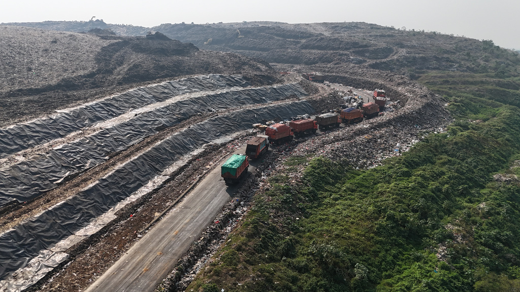 Garbage trucks line up before unloading waste at the Bantargebang landfill on the outskirts of Jakarta, Indonesia, Monday, July 6, 2026. (AP Photo/Tatan Syuflana)