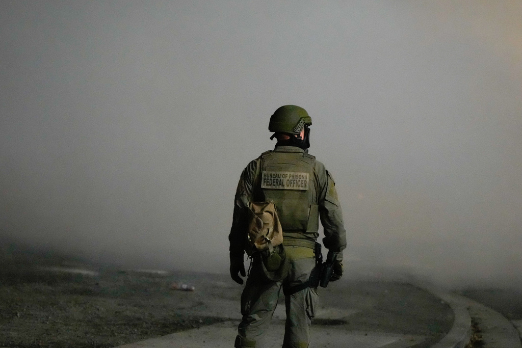 A law enforcement officer stands after tear gas was deployed outside a U.S. Immigration and Customs Enforcement facility during a protest on Saturday, Oct. 4, 2025, in Portland, Ore. (AP Photo/Jenny Kane)