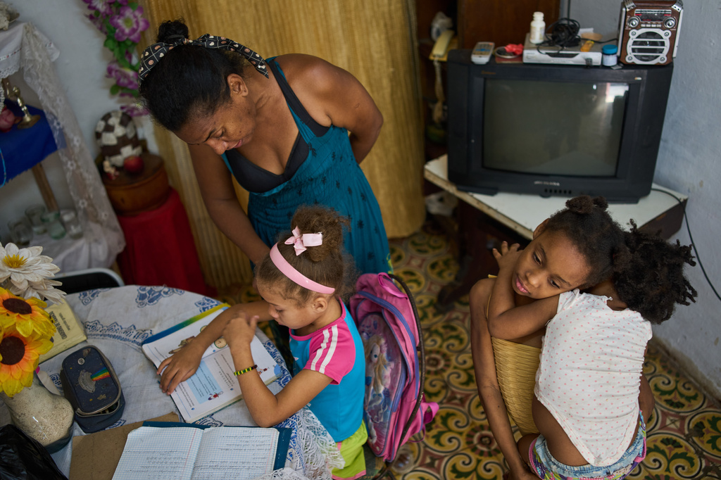FILE - Yuneisy Riviaux helps her daughter Edianet with her homework at their home in Havana, Cuba, March 25, 2026. (AP Photo/Ramon Espinosa, File)