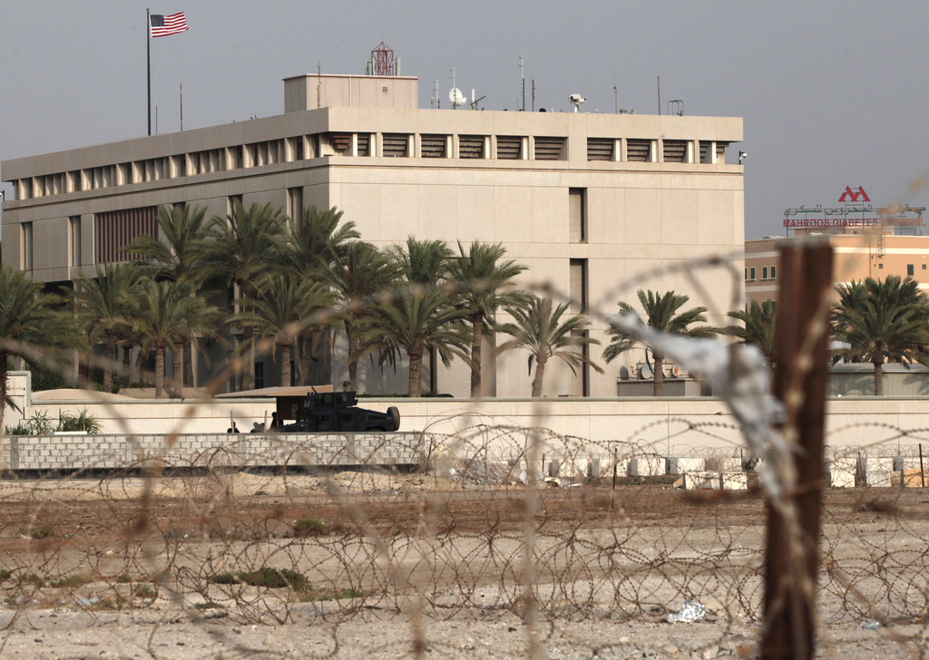 FILE - A Bahraini armored personnel vehicle and personnel reinforce U.S. Embassy security just outside of a gate to the building, surrounded in barbed wire, in Manama, Bahrain, Aug. 4, 2013.(AP Photo/Hasan Jamali, File)
