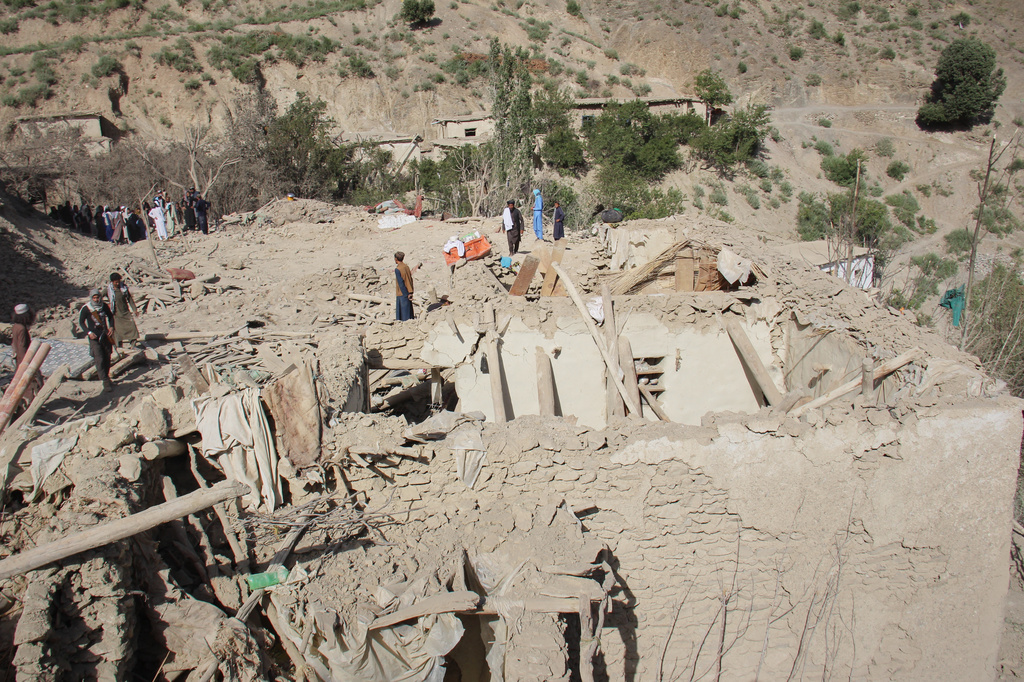 Residents stand on the ruins of mud-brick homes after airstrikes that Taliban officials said were carried out by Pakistan and killed civilians, including children, in Mana, a village in Afghanistan's Khost province, Wednesday, June 10, 2026. (AP Photo/Saifullah Zahir)