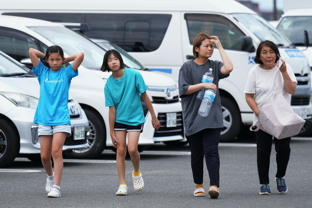 People arrive at the Hikawa Town Hall to receive food and water supplies in Hikawa, southern Japan, Thursday, July 30, 2026, two days after an earthquake hit the area. (AP Photo/Hiro Komae)