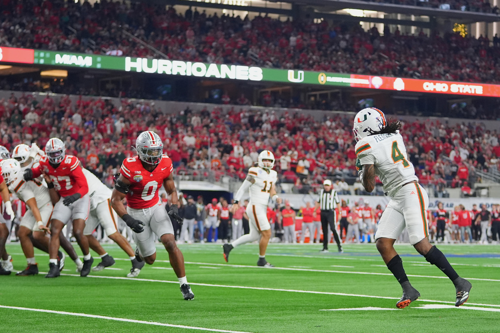 Miami running back Mark Fletcher Jr. (4) catches a pass from quarterback Carson Beck (11) before running int in for a touchdown in front of Ohio State linebacker Sonny Styles (0) during the first half of the Cotton Bowl College Football Playoff quarterfinal game Wednesday, Dec. 31, 2025, in Arlington, Texas. (AP Photo/Julio Cortez)