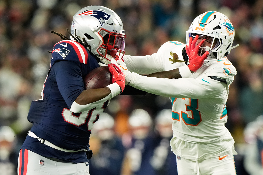 New England Patriots running back Rhamondre Stevenson, left, stiff arms Miami Dolphins cornerback while running for a touchdown during the second half of an NFL football game in Foxborough, Mass., Sunday, Jan. 4, 2026. (AP Photo/Robert F. Bukaty)