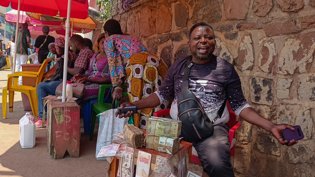 A currency exchanger buys perforated notes that are rejected by people in Bukavu, Democratic Republic of the Congo, Friday, Aug 29, 2025. (AP Photo)